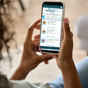 Woman holding phone looking at a custom made meal plan