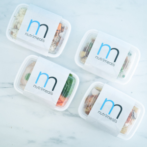 containers of meal prep on white marble background