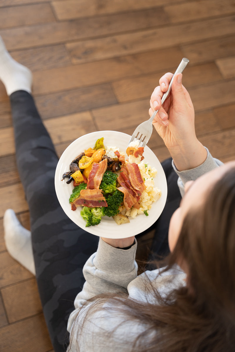 Person sitting and eating a fresh prepared meal