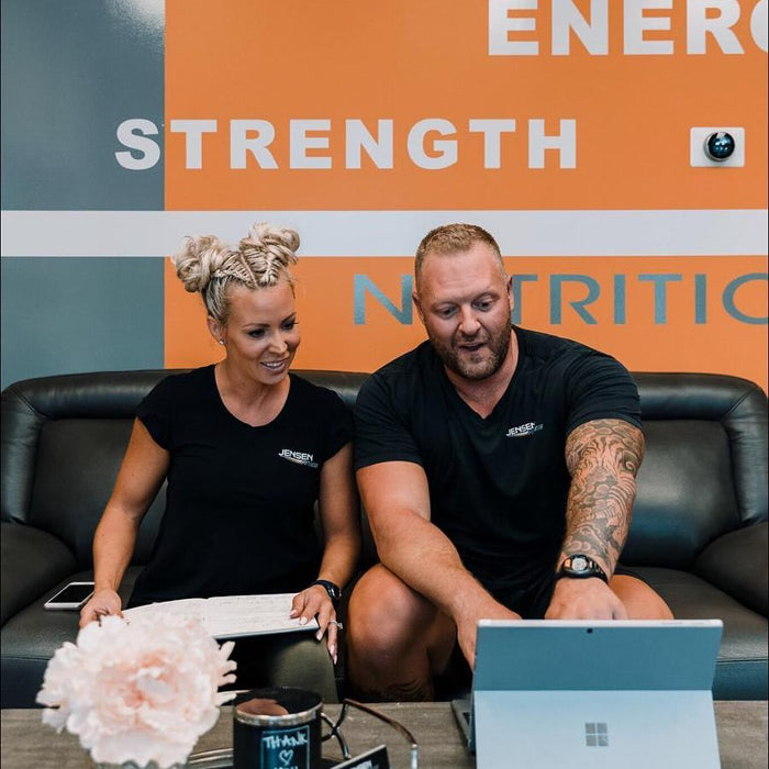 woman and man sitting next together on a couch pointing at a computer screen