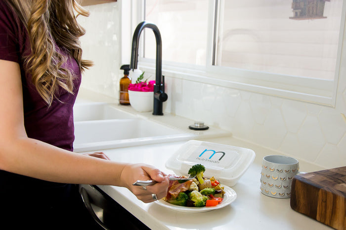Girl eating broccoli off a plate