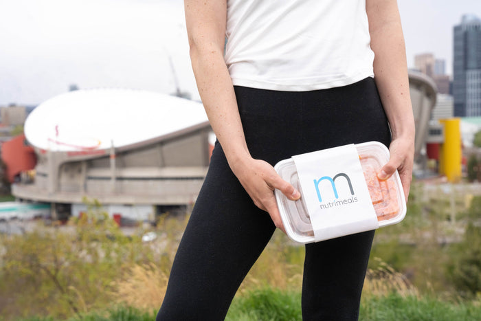 Girl holding meal standing in front of saddledome in calgary