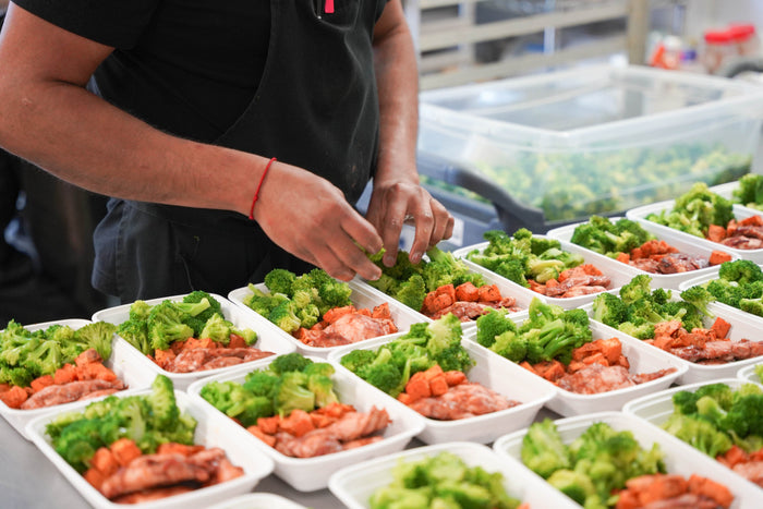 Man making healthy meal prep and putting ingredients into containers 