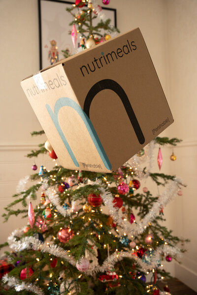 nutrimeals box in front of a christmas tree