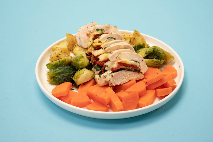 sundried tomato stuffed chicken on a plate of vegetables