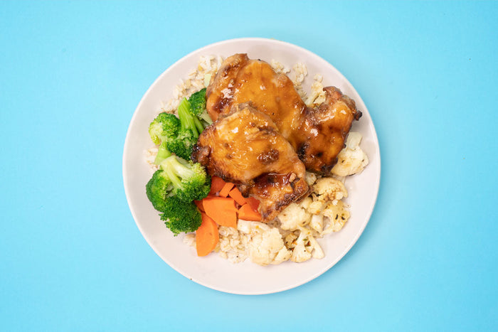 plate of food with rice, teriyaki chicken, cauliflower, carrots and broccoli