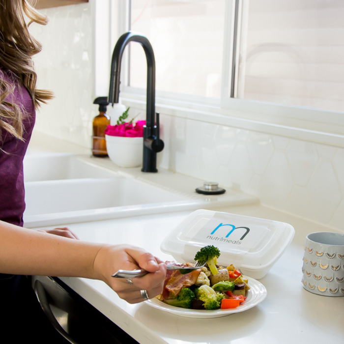 Person eating a fresh prepared meal and vegetables