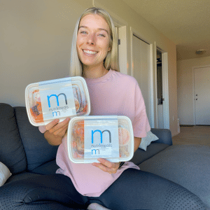 Girl sitting on couch holding nutrimeals containers