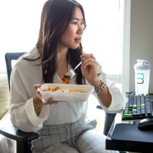 Girl sitting at work desk eating a healthy meal
